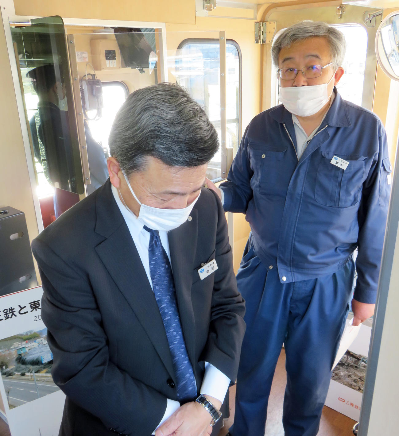 午後2時46分、宮古市の閉伊川橋りょうで黙とうする中村社長（左）とガイド役の冨手副部長（撮影・鎌田直秀）
