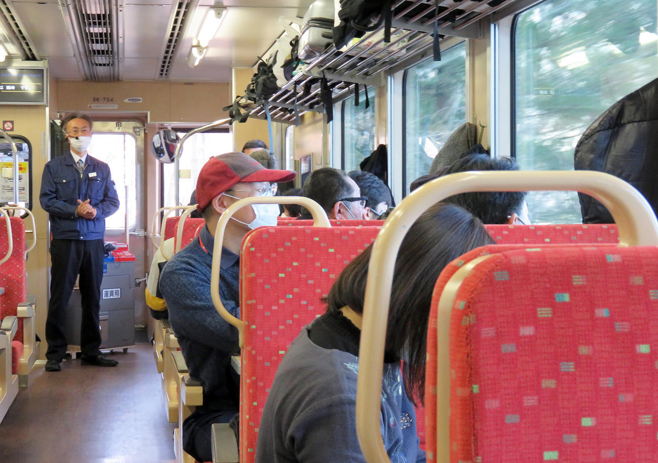 三陸鉄道社員のガイドを聞きながら景色を見つめる「感謝のリレー列車」の乗客たち（撮影・鎌田直秀）