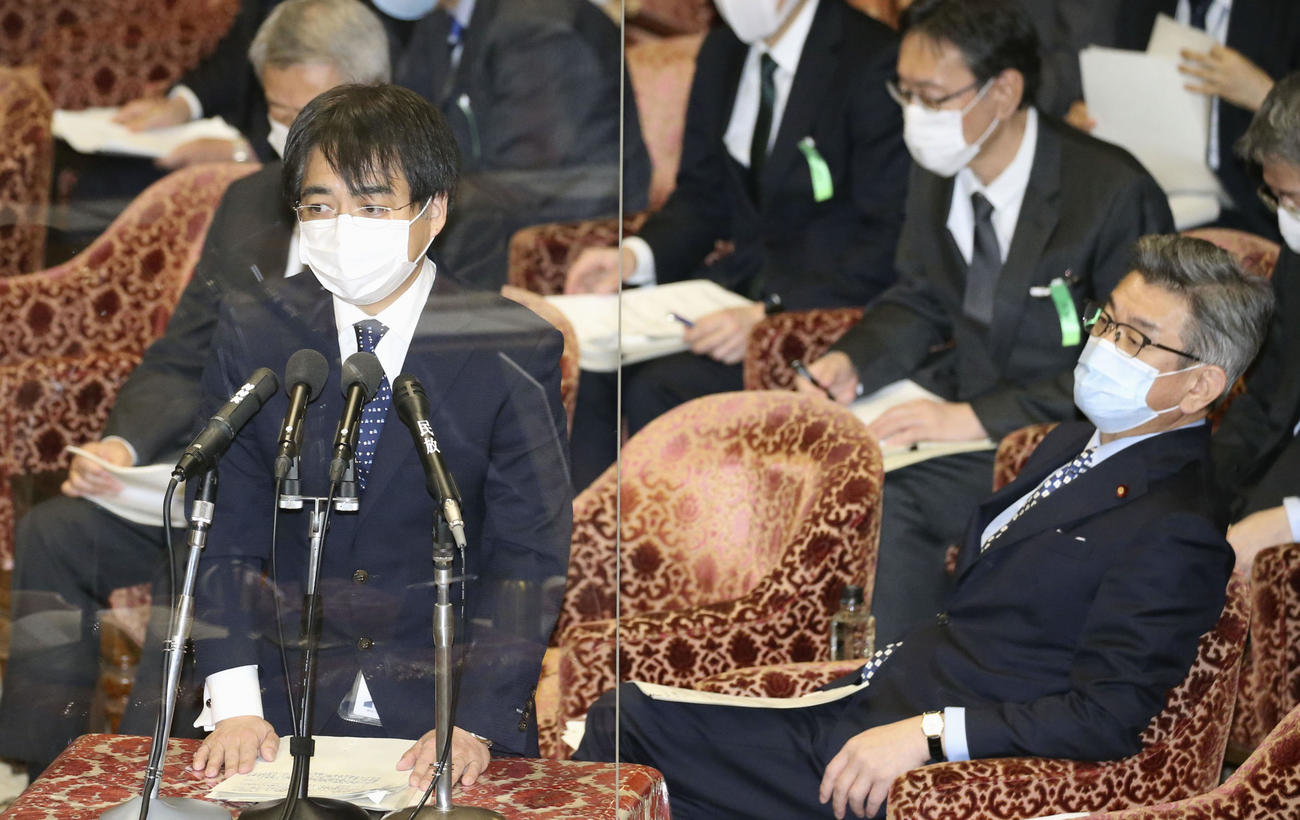 衆院予算委で質問に答える総務省の鈴木信也電波部長。右は武田総務相（共同）