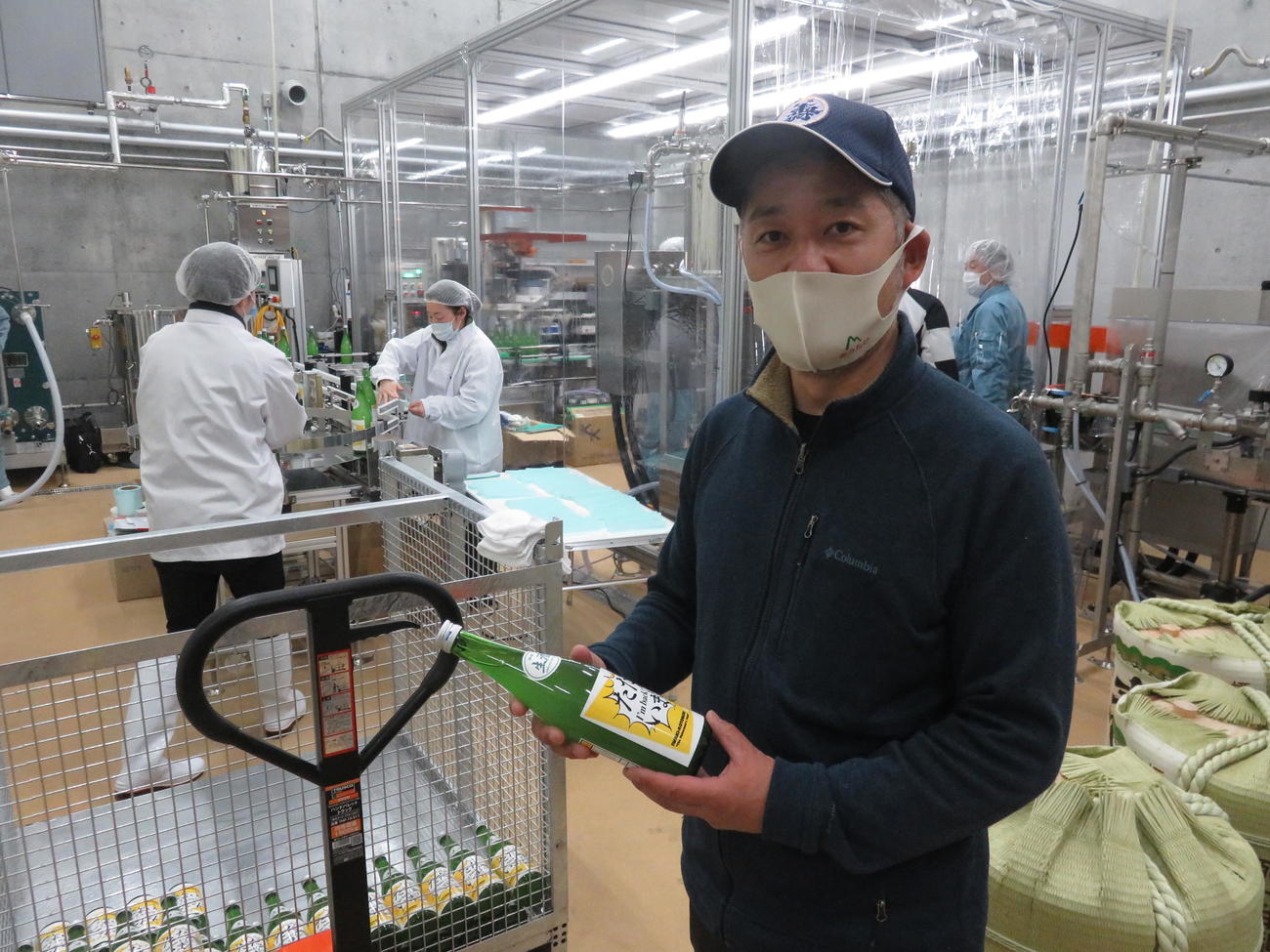 瓶詰めされた「磐城壽ランドマーク」を手に取る鈴木酒造店の社長で杜氏（とうじ）の鈴木大介さん