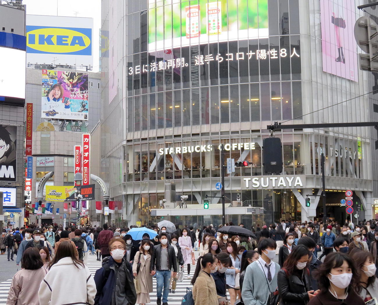 渋谷駅ハチ公口前のスクランブル交差点を行き交うマスク姿の人たち