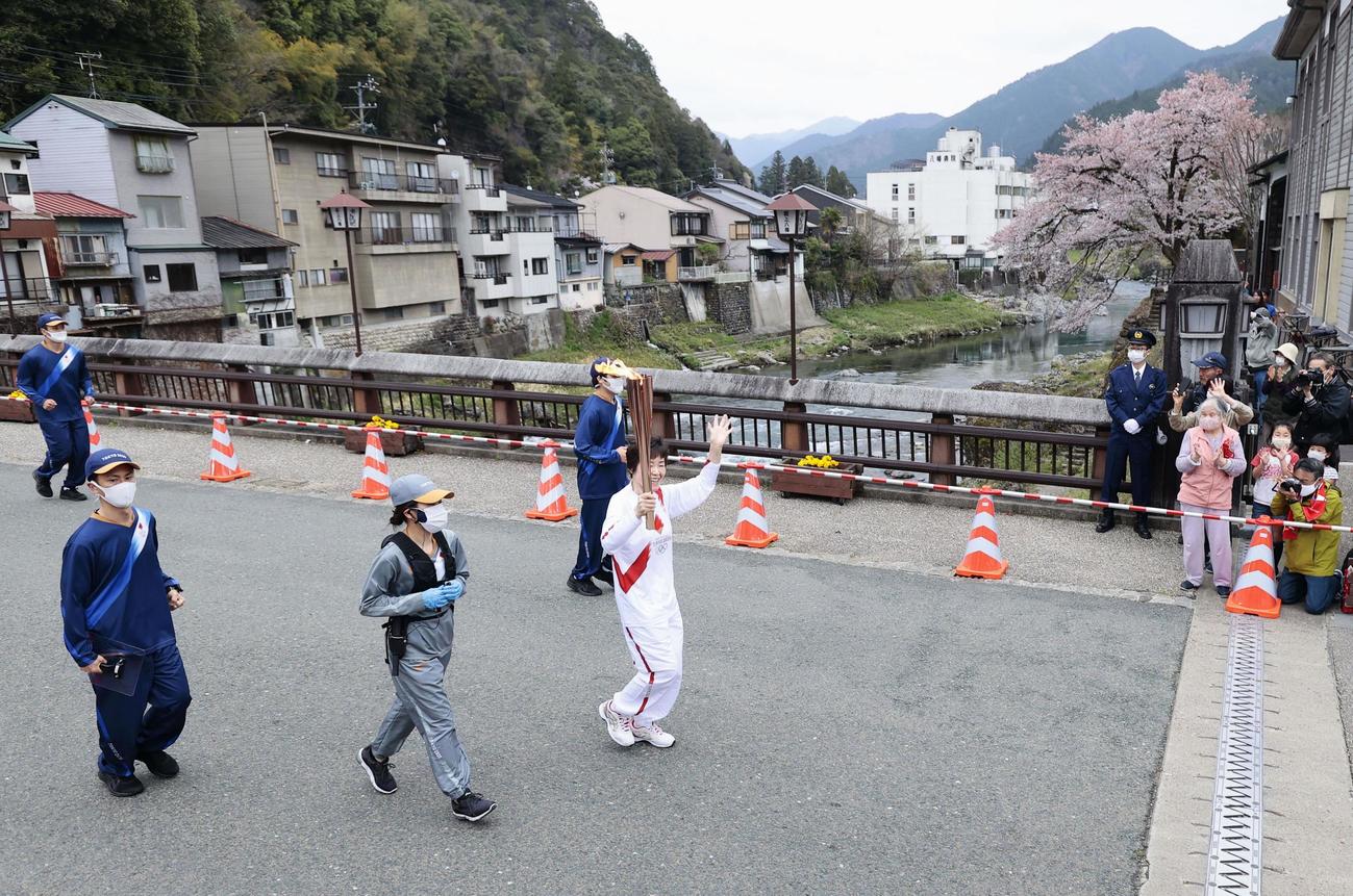 郡上八幡城の城下町を走る聖火ランナー（共同）
