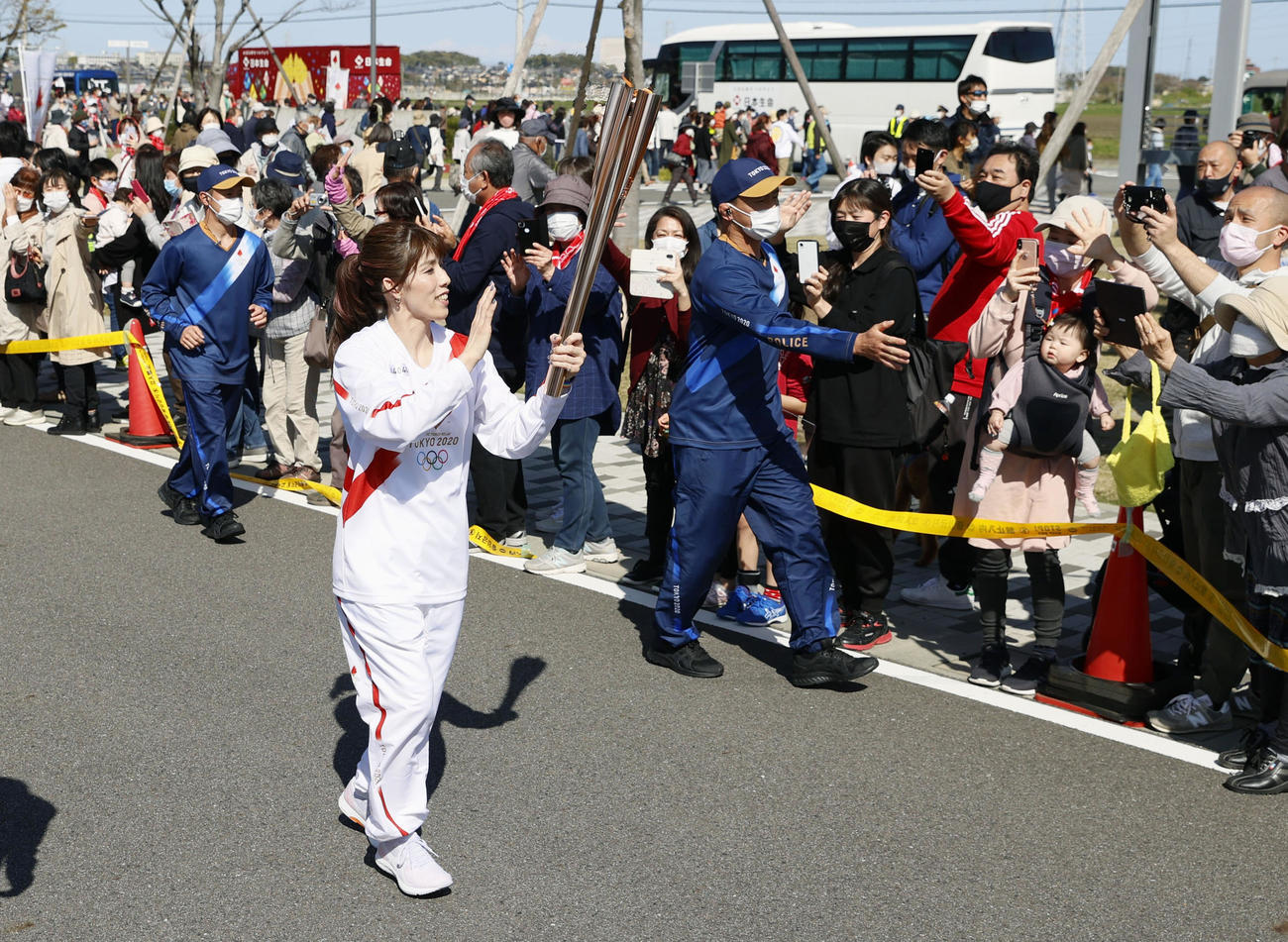 沿道の人たちに手を振りながら故郷の津市を走る聖火ランナーの吉田沙保里さん（共同）