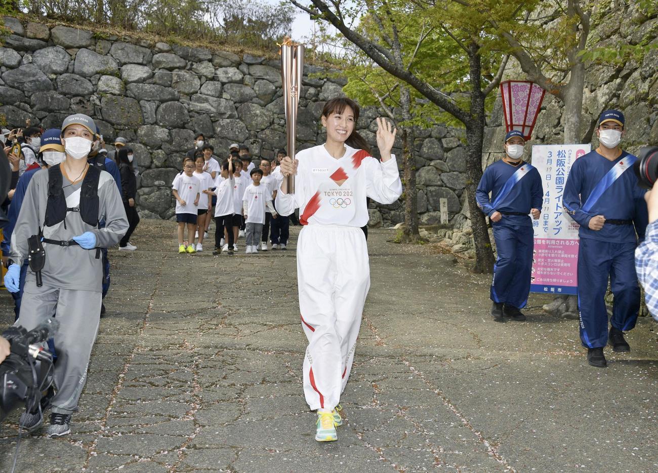 松坂城の石垣を背に走る聖火ランナーの浅尾美和さん