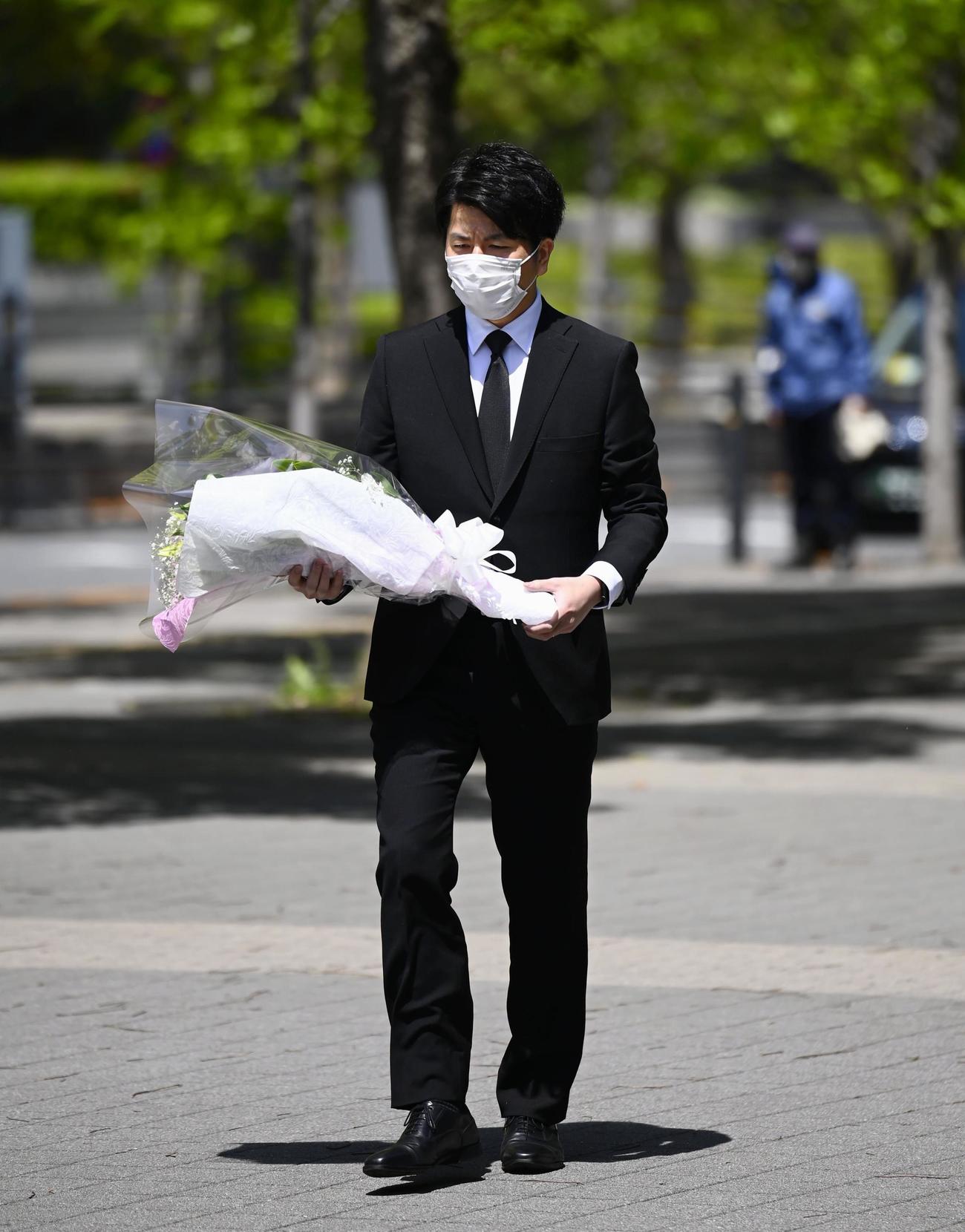 東京・池袋の乗用車暴走事故から2年となり、花束を手に現場付近の慰霊碑を訪れる遺族の松永拓也さん（共同）