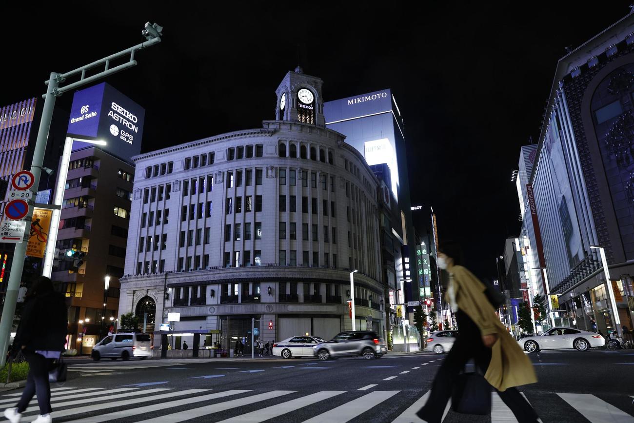 緊急事態宣言が発令された東京・銀座の「和光本館」（中央）。ライトアップの時間を短縮し、午後8時に終了した（共同）
