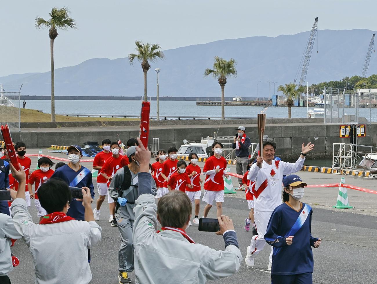 鹿児島の志布志港を走る聖火ランナーの岩本大介さん（共同）