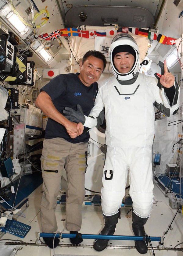 国際宇宙ステーションで地球帰還を控え、星出彰彦さん（左）と握手する野口聡一さん（星出さんのツイッターから）（共同）