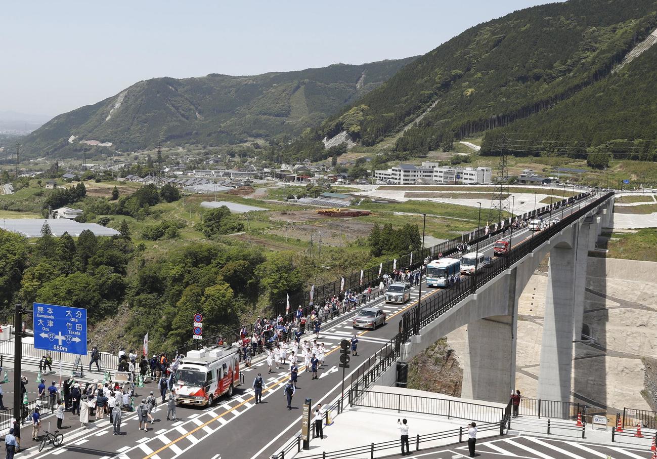 熊本県南阿蘇村の新阿蘇大橋を渡る東海大九州キャンパスの学生らグループの聖火ランナー（共同）