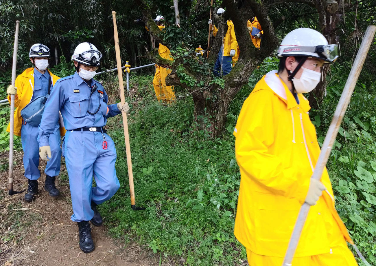 裏山東側の捜索を終えて下山する消防隊員