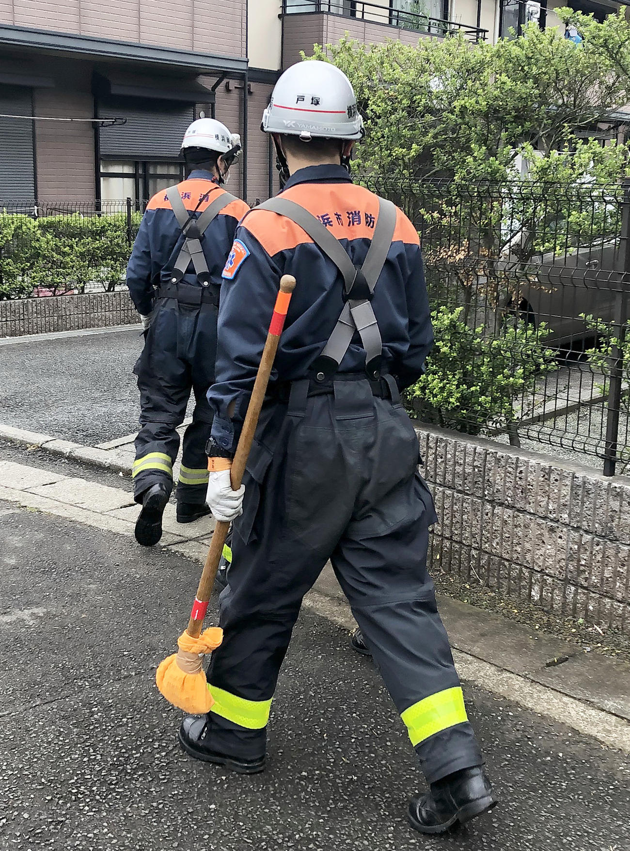 アミメニシキヘビ捜索のため飼い主のアパート内に向かう消防隊員たち（撮影・阿部泰斉）