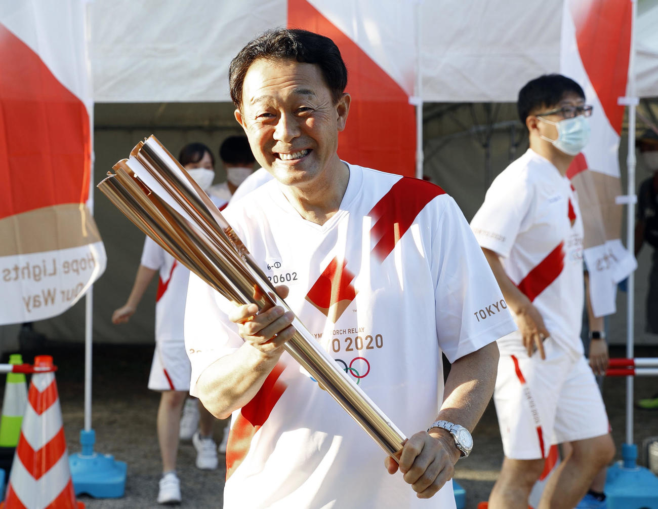 聖火のトーチでバントの構えをする川相昌弘さん