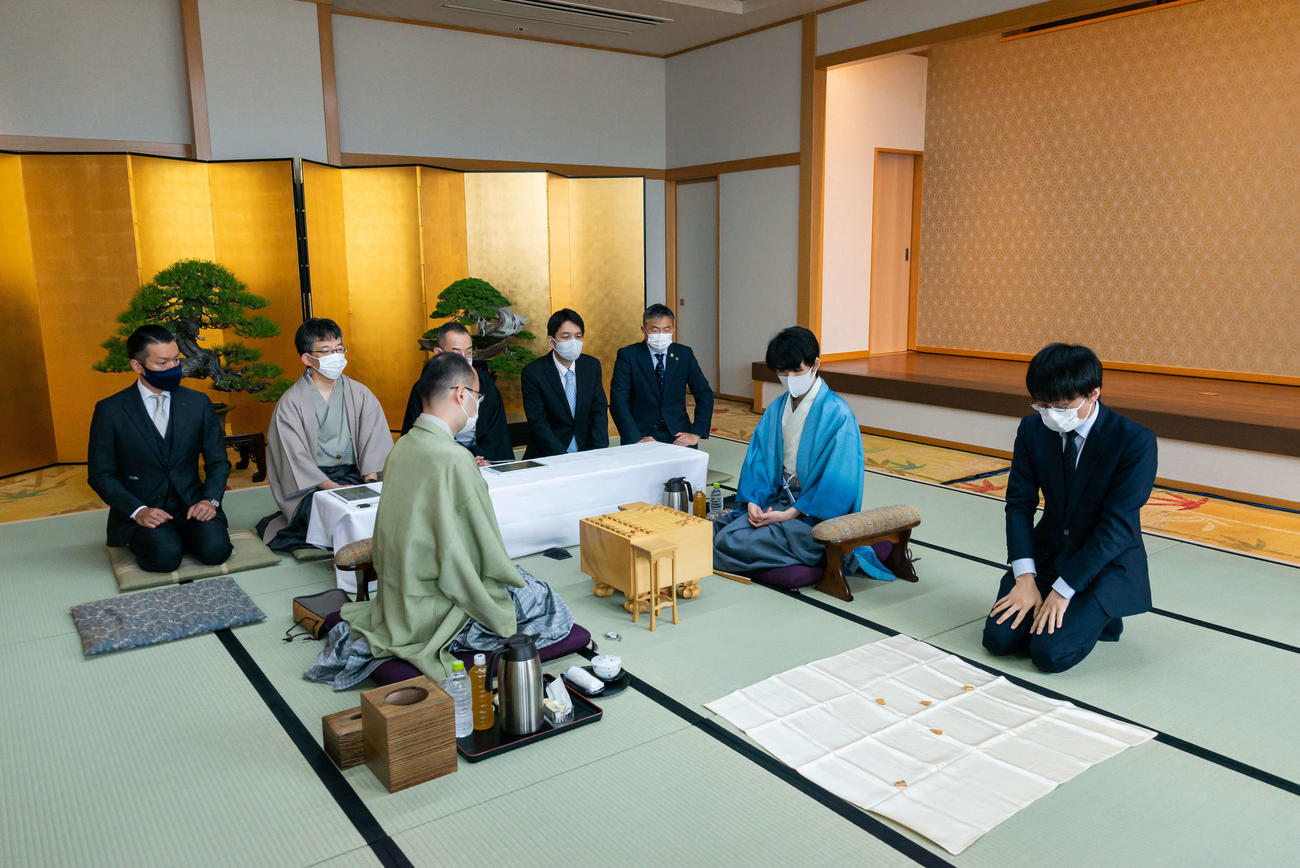 第92期ヒューリック杯棋聖戦5番勝負第1局、先後を決める振り駒の結果を見る藤井聡太2冠（右）、渡辺明名人（日本将棋連盟提供）