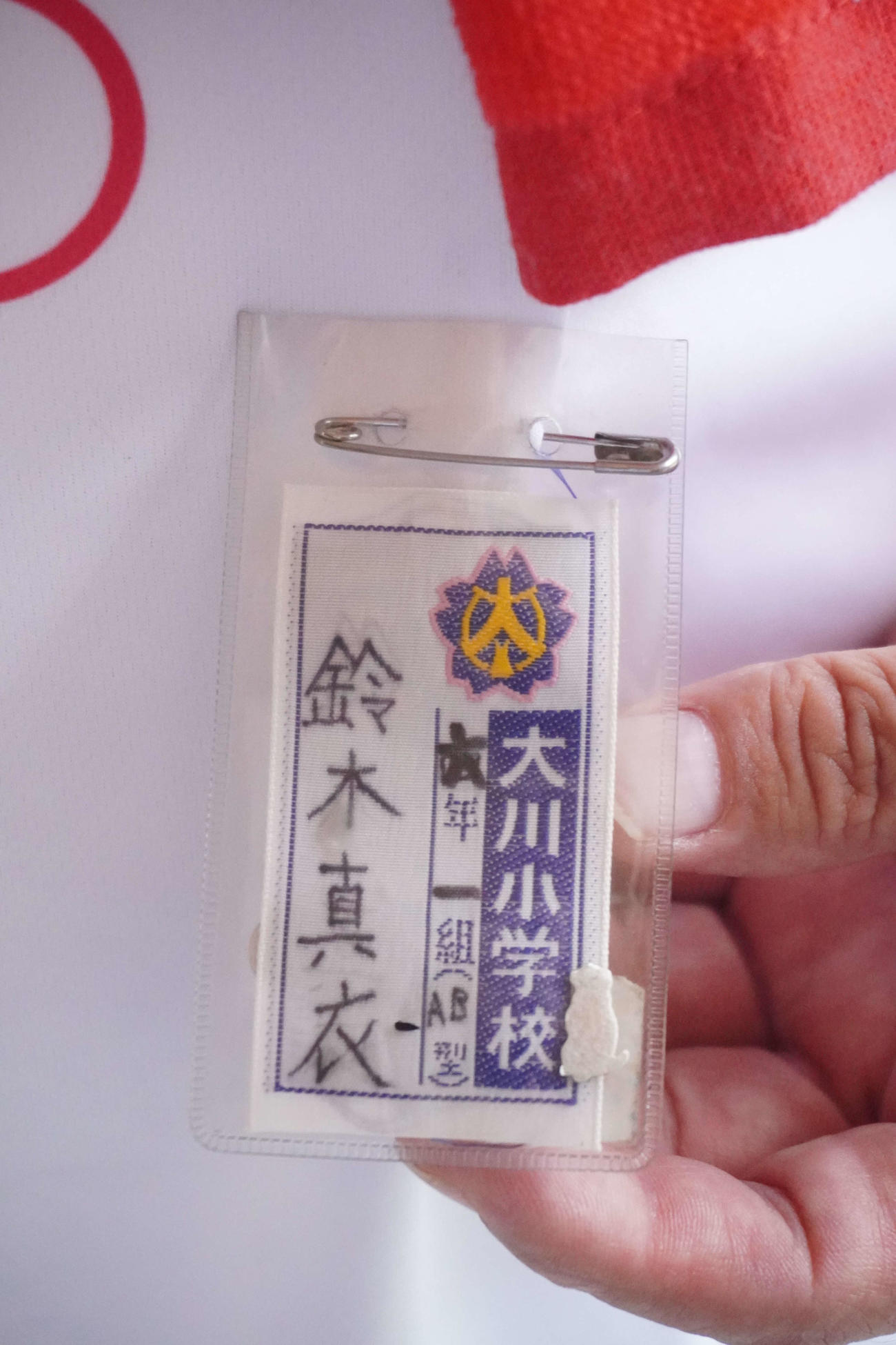 鈴木典行さんが身につけていた、真衣さん直筆の名札撮影・沢田直人）