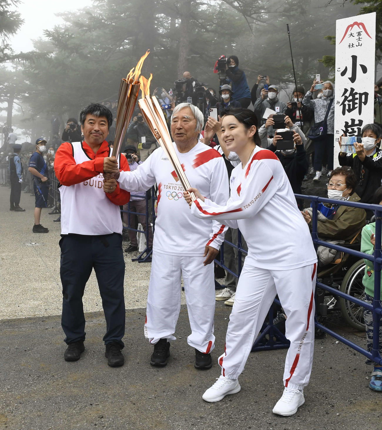 聖火ランナーを務めた冒険家の三浦雄一郎さん（中央）とサポートする息子の豪太さん（左）。手前は前走者の矢野育帆さん（代表撮影）