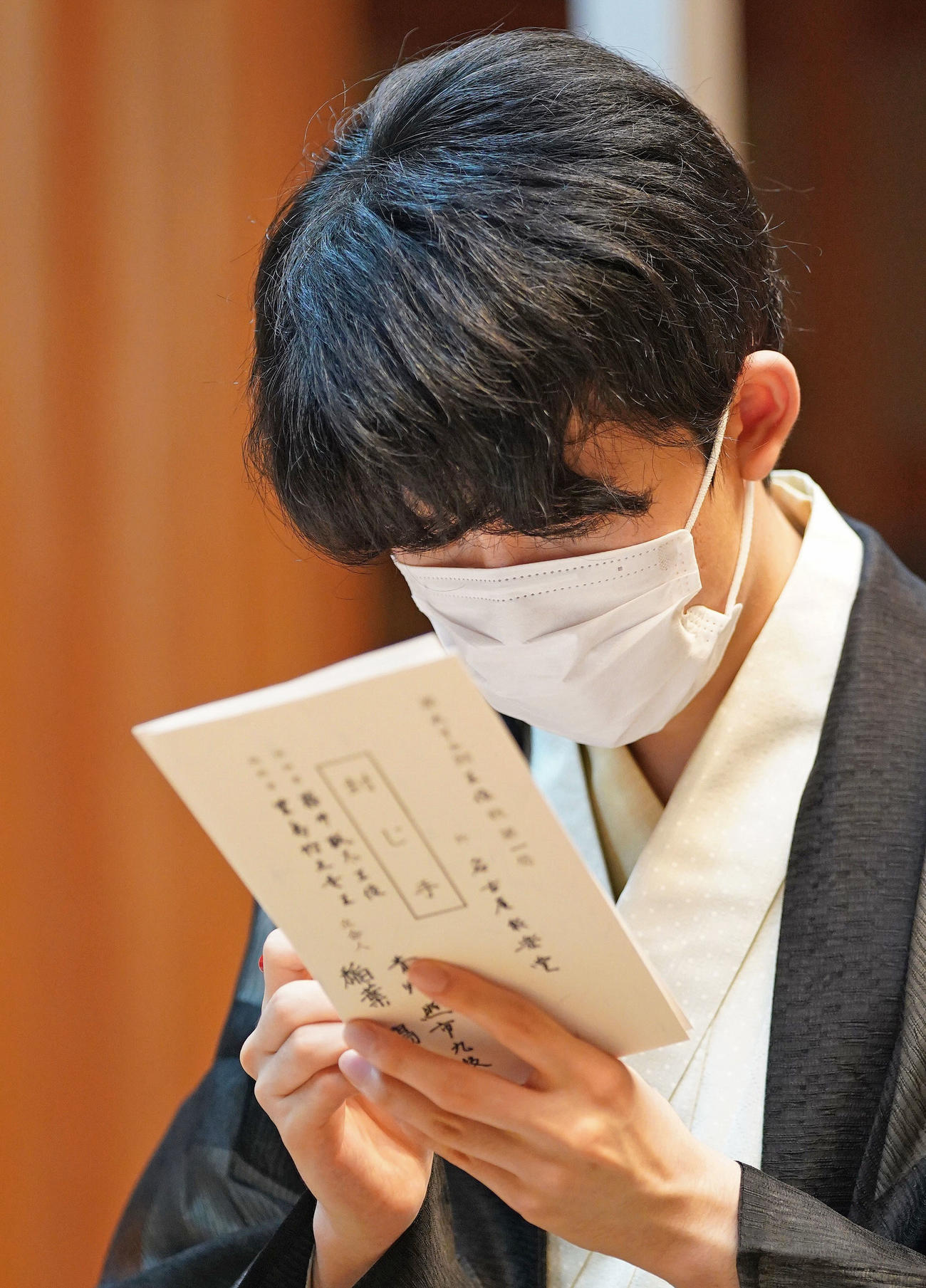 王位戦7番勝負第1局の1日目を終え、封じ手が入った封筒に署名する藤井聡太王位（代表撮影）