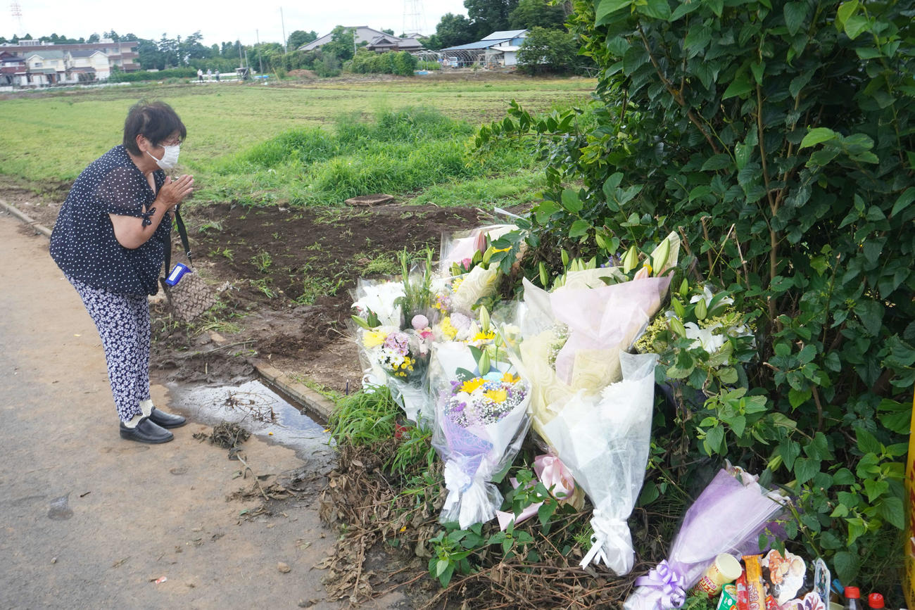 事故現場に花を供え、手を合わせる地元住民（撮影・沢田直人）
