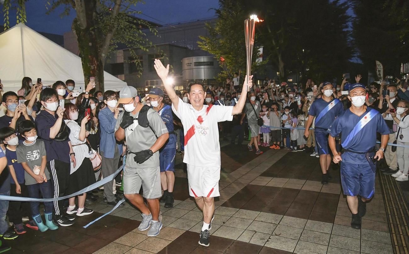聖火のトーチを掲げて走る毛利衛さん（代表撮影）