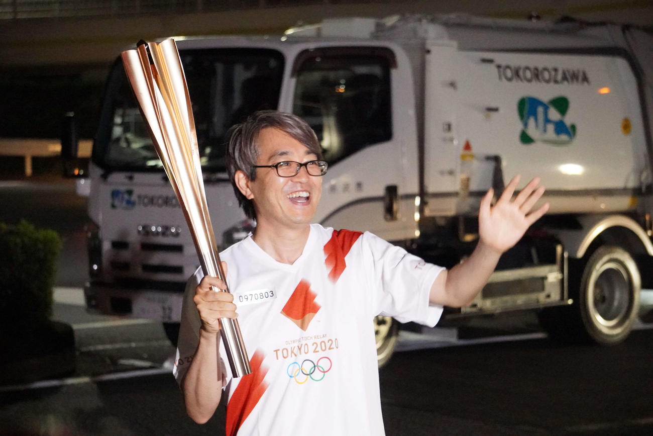 聖火をともす前に沿道の観客に笑顔で手を振る羽生善治氏（撮影・沢田直人）