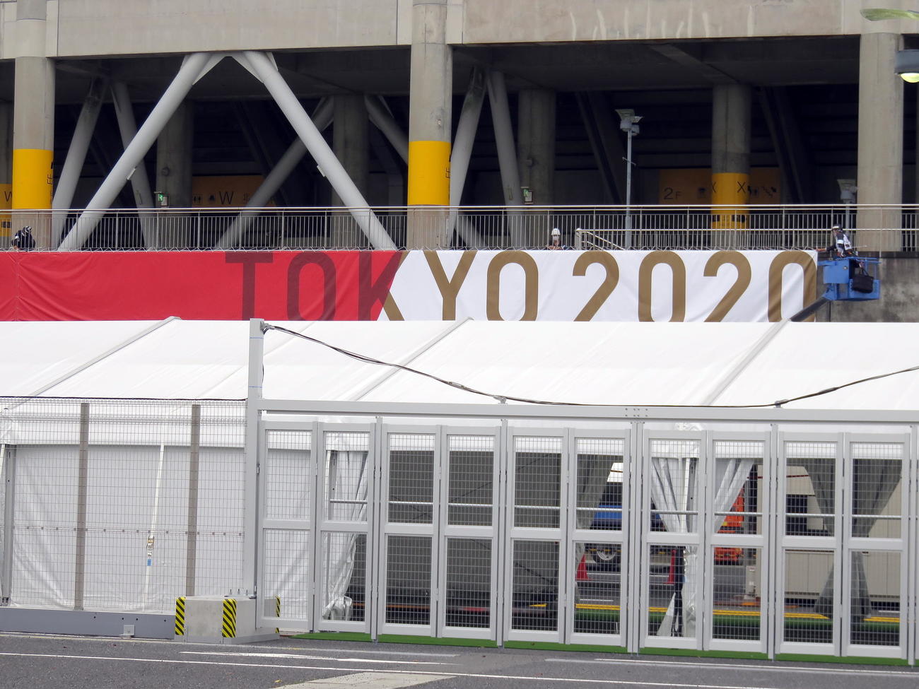 カシマスタジアムに「TOKYO2020」の幕などを設置する作業員（撮影・鎌田直秀）