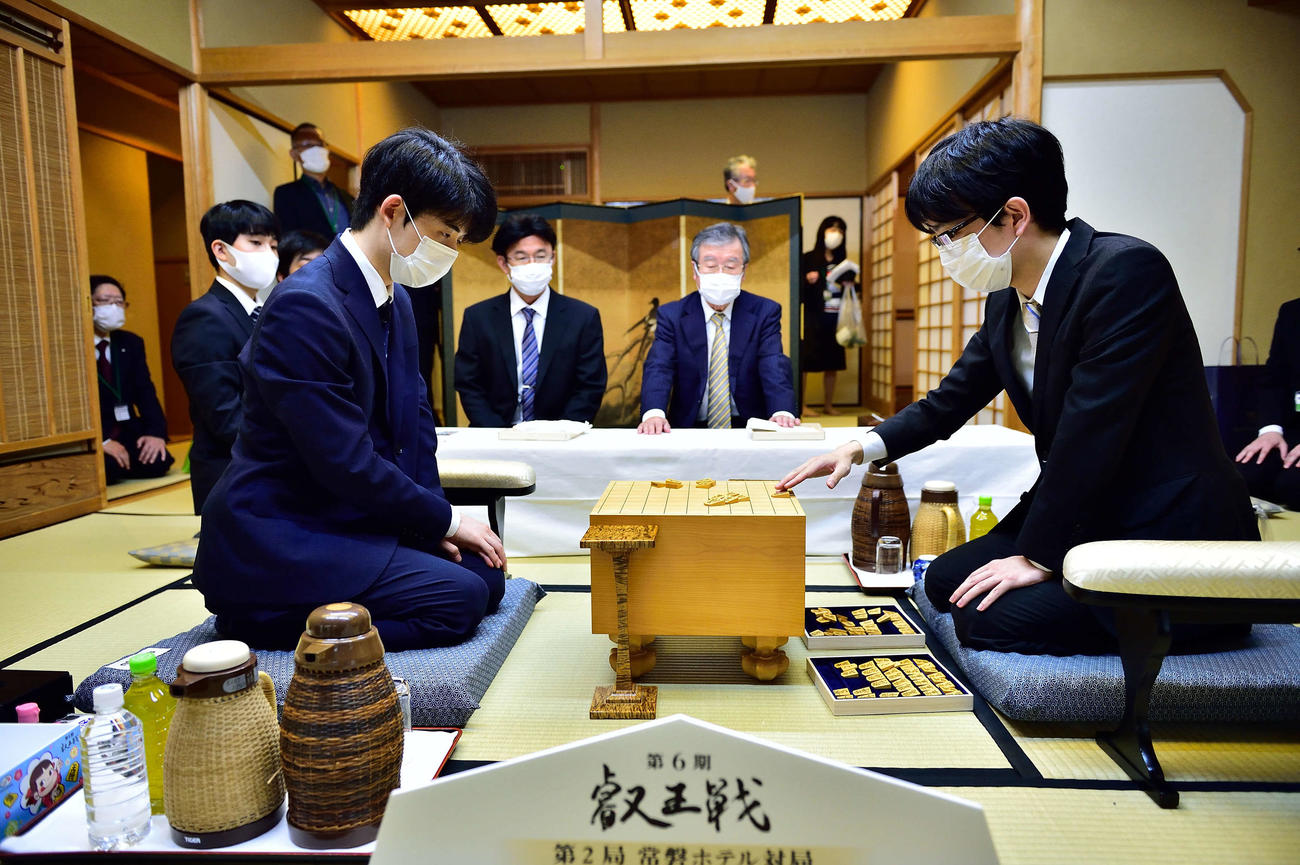 対局場で盤や駒の検分を行う豊島将之叡王（右）と挑戦者の藤井聡太2冠（左、日本将棋連盟提供）