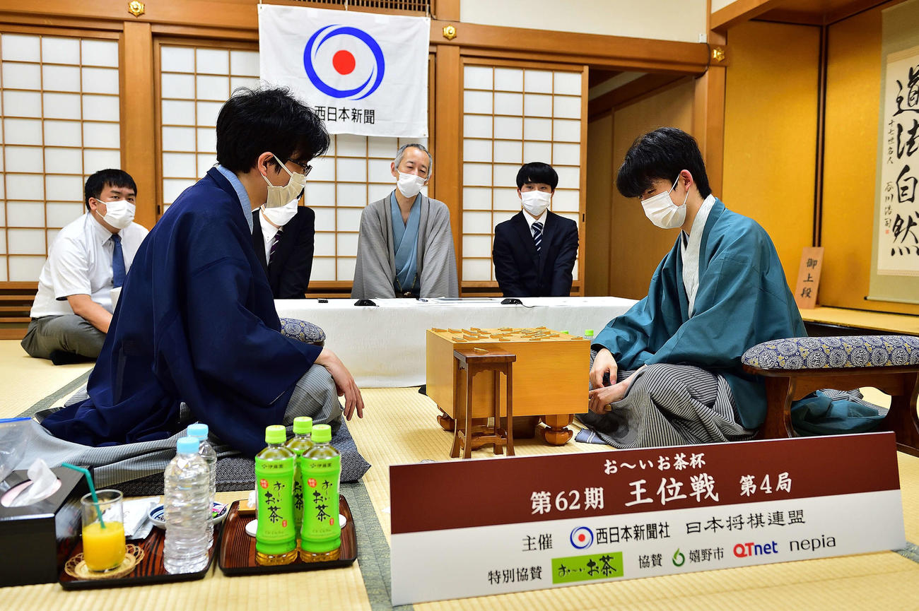 終局後、感想戦を行う藤井聡太王位。左は豊島将之竜王（日本将棋連盟提供）