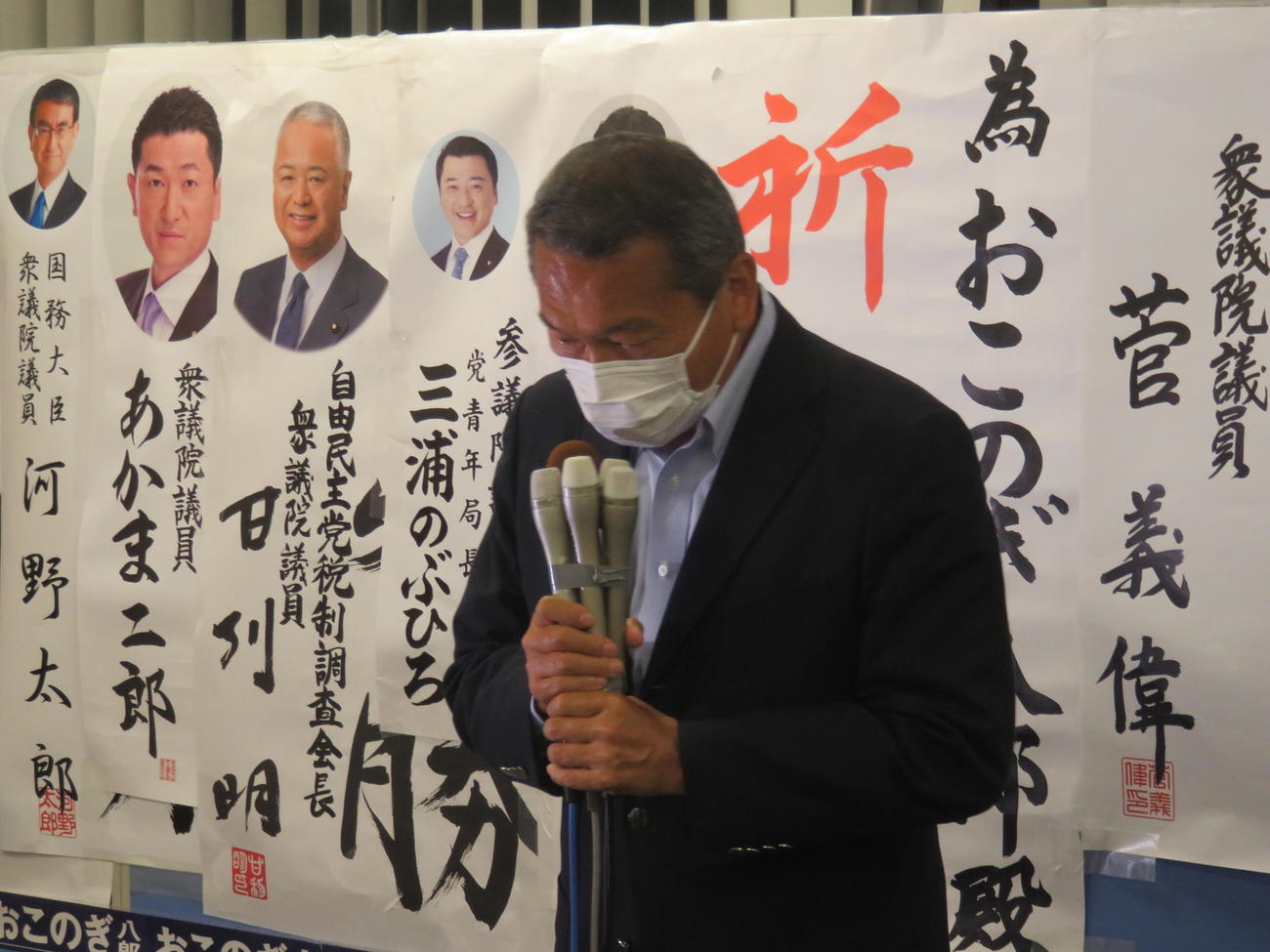 菅首相から贈られた為書きの前で頭を下げる小此木八郎氏。政界を引退することを明らかにした