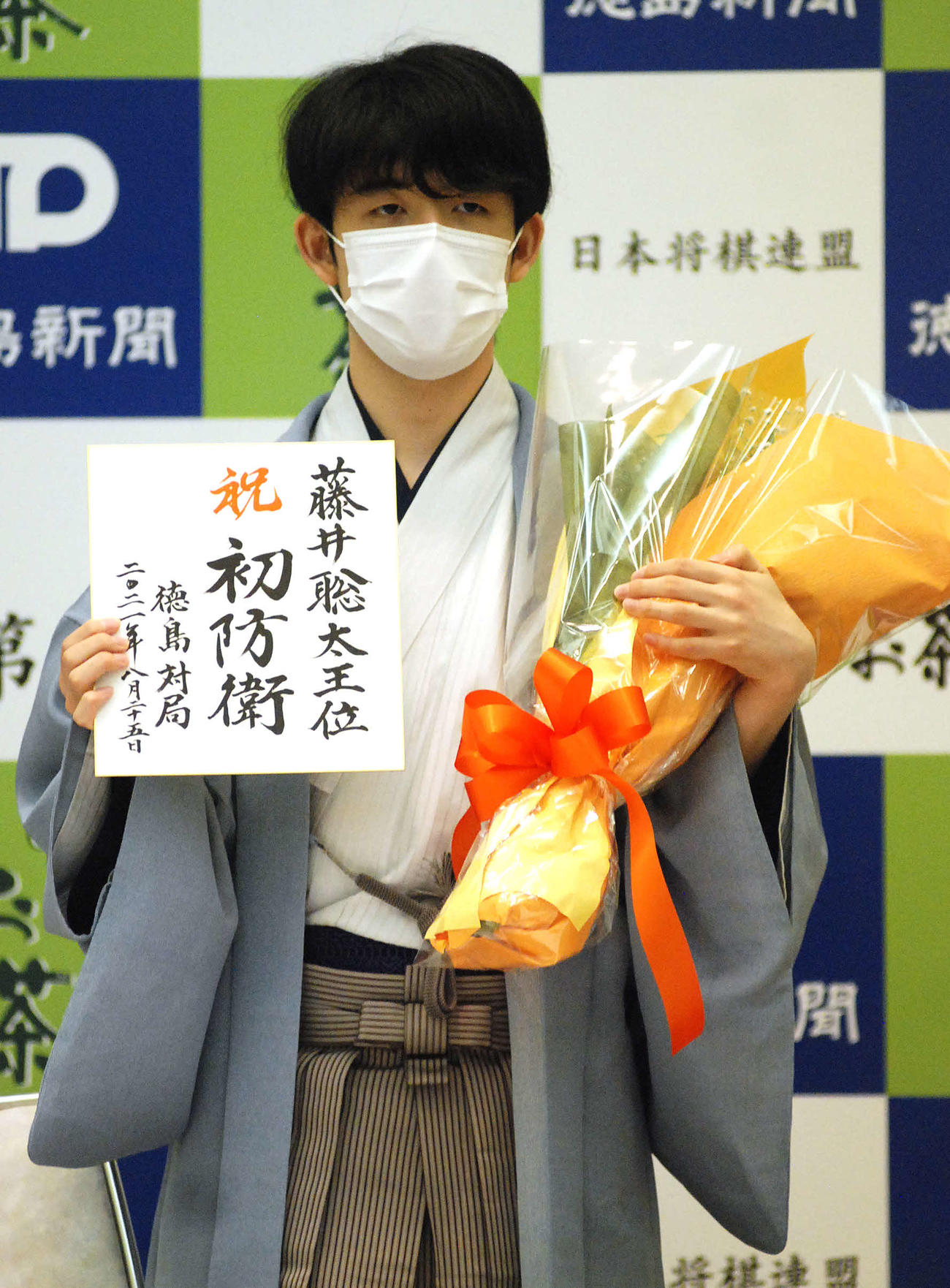 第62期王位戦で初防衛を果たし、花束と色紙を手にする藤井聡太王位（撮影・松浦隆司）