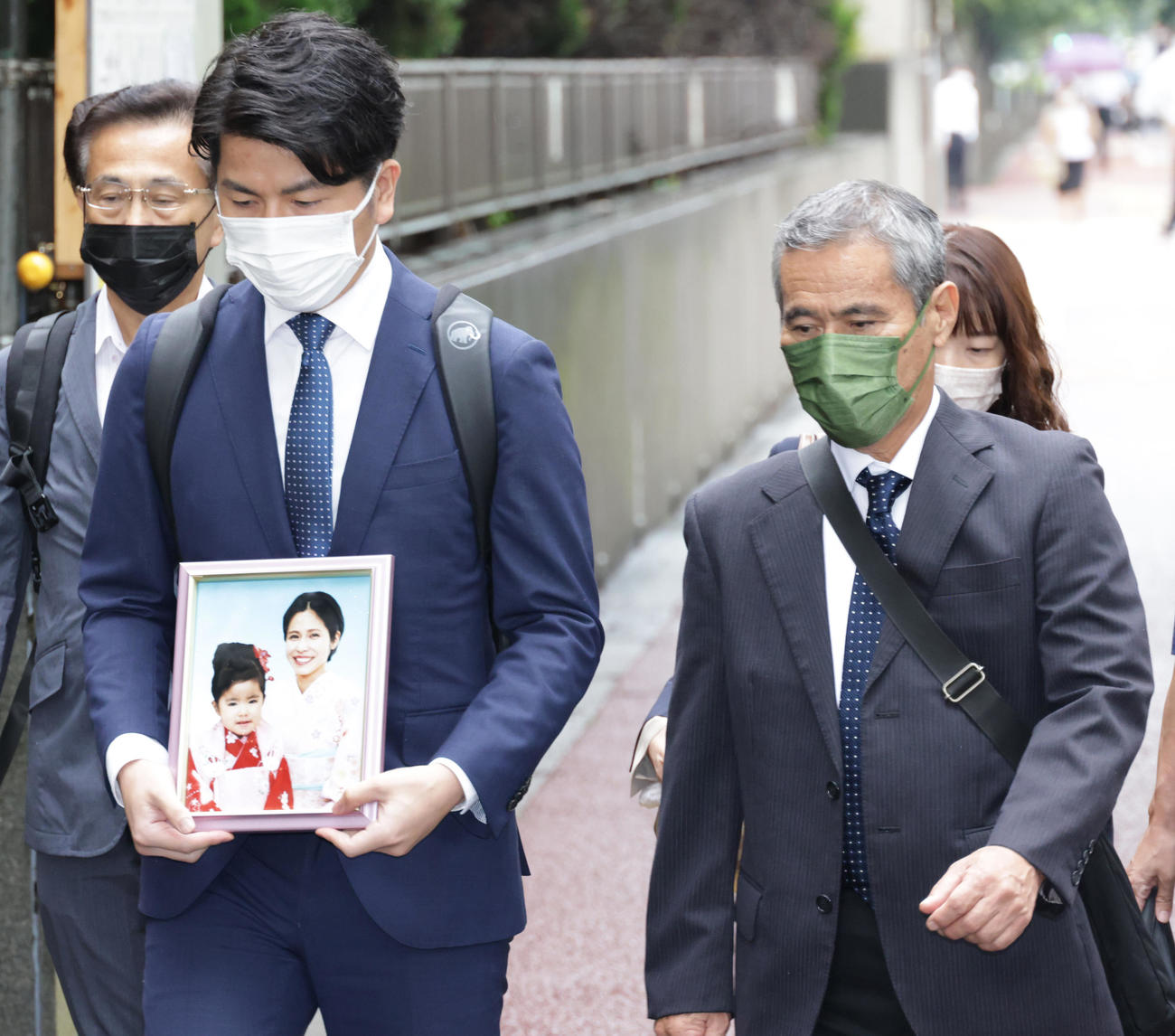 妻・松永真菜さんと長女・莉子ちゃんの遺影を胸に東京地方裁判所を訪れた松永拓也さん（左）（撮影・中島郁夫）