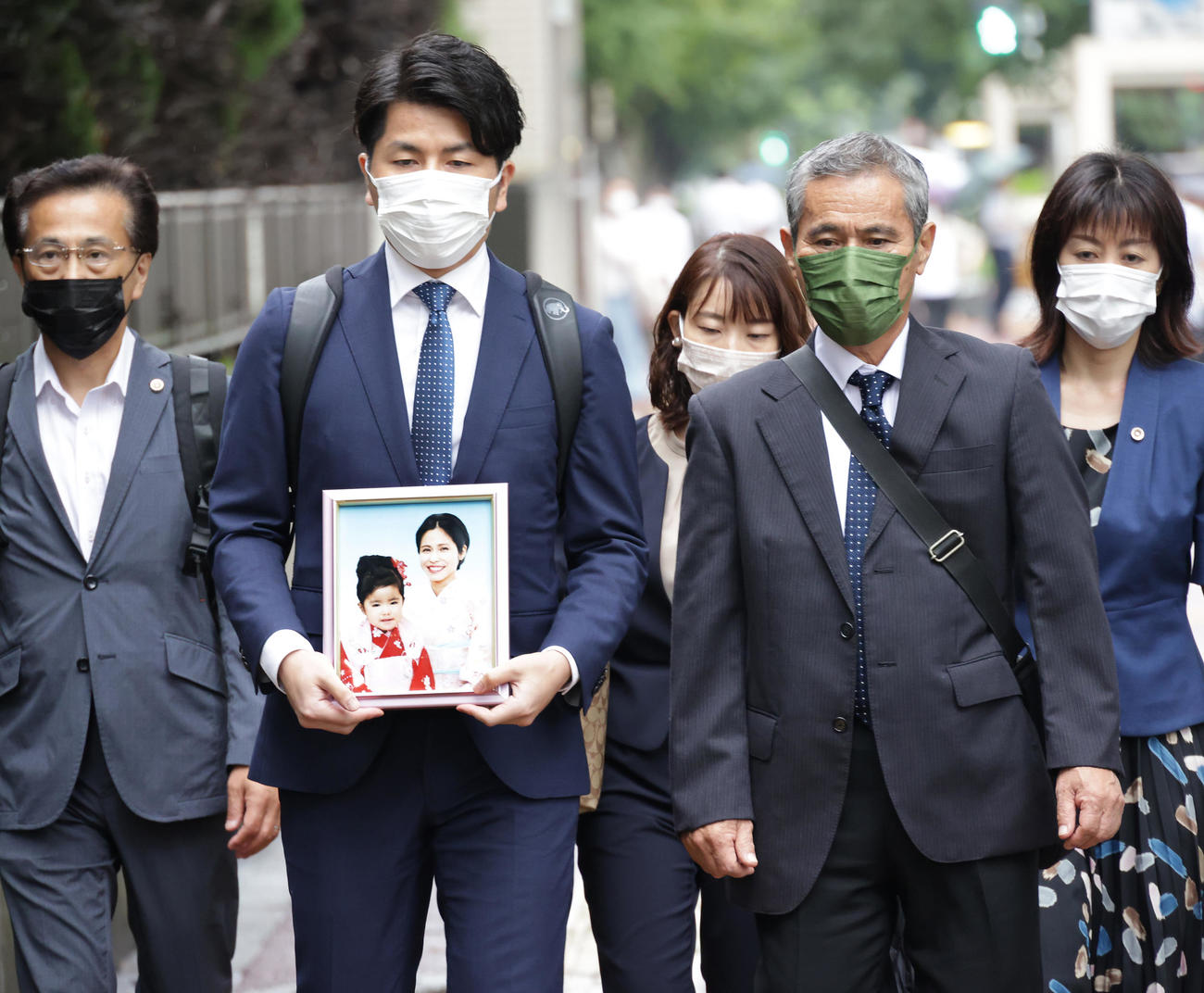 妻・松永真菜さんと長女・莉子ちゃんの遺影を胸に東京地方裁判所を訪れた松永拓也さん（左）（撮影・中島郁夫）