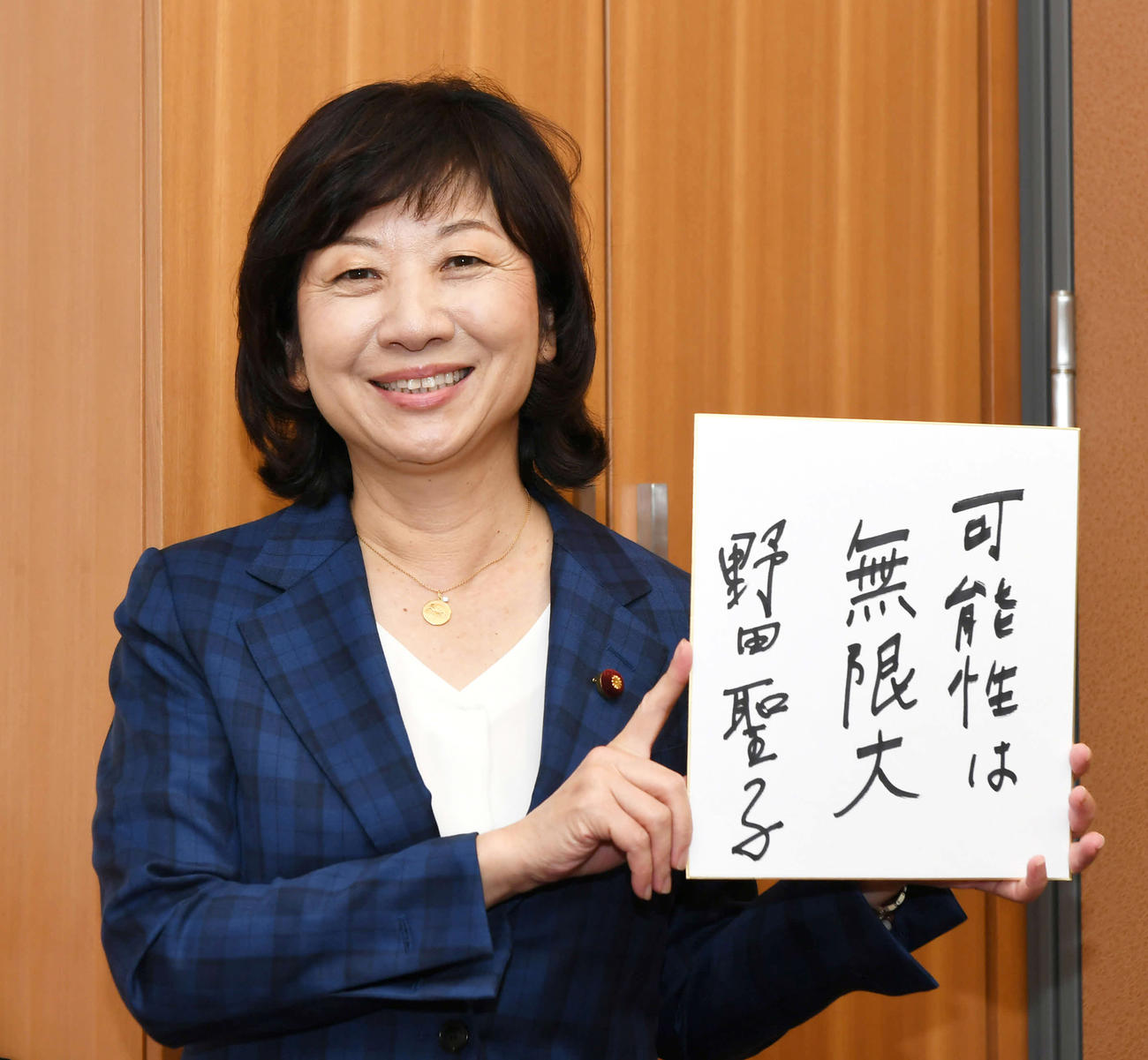 「可能性は無限大」と書いた色紙を手に、笑顔を見せる野田聖子幹事長代行（撮影・酒井清司）