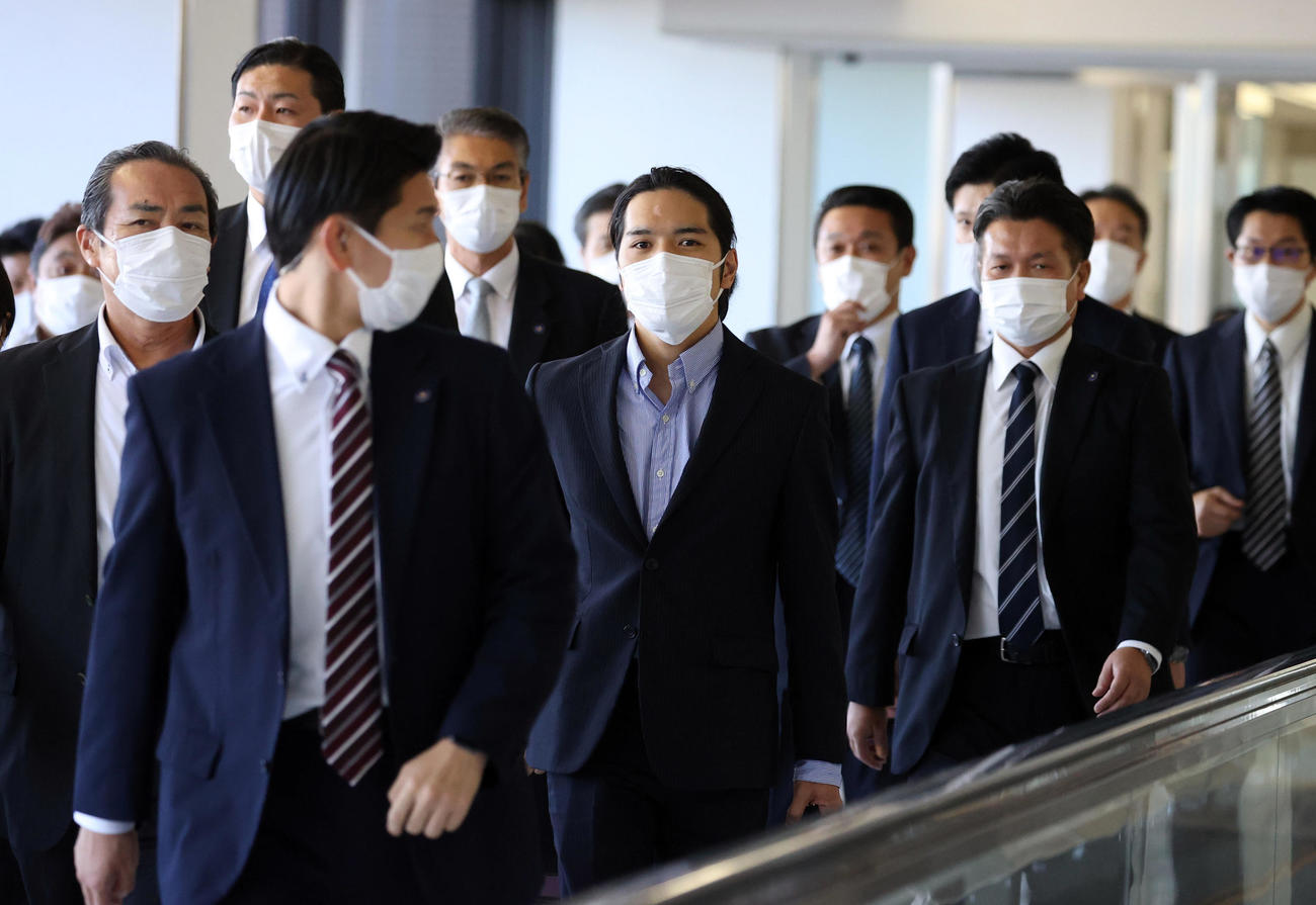 成田空港に到着し、多くの関係者に囲まれながら、到着ゲートを歩く小室圭さん（撮影・狩俣裕三）