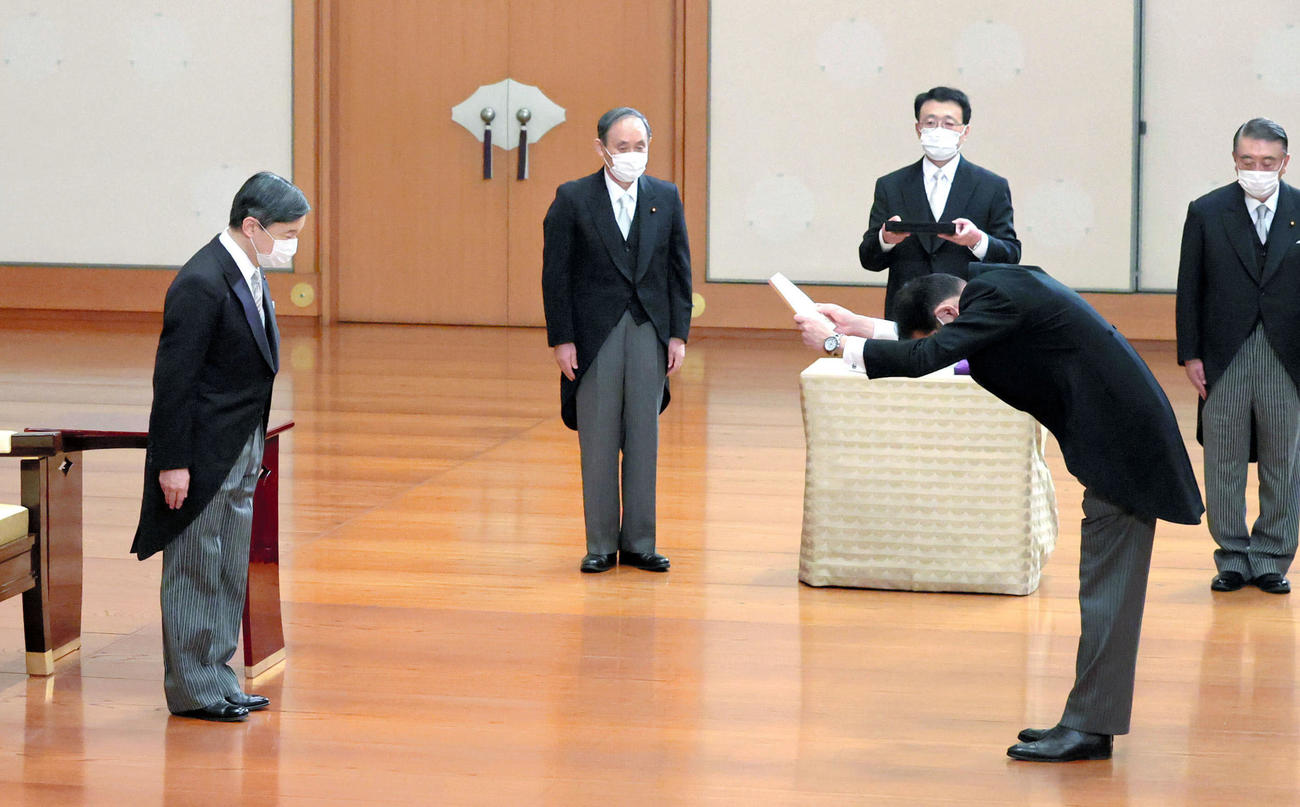 天皇陛下から任命を受ける岸田文雄首相。中央は菅義偉前首相（共同）