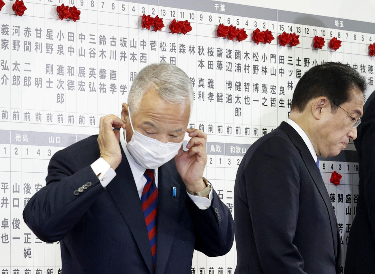 自民党本部の開票センターで総裁の岸田首相（右）と記念撮影を終えた甘利幹事長。小選挙区で敗北した（共同）