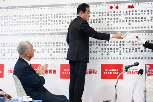 岸田文雄総裁（右）が自身の名前の上に当選の花を付けなかったことを見守る甘利明幹事長（代表撮影）