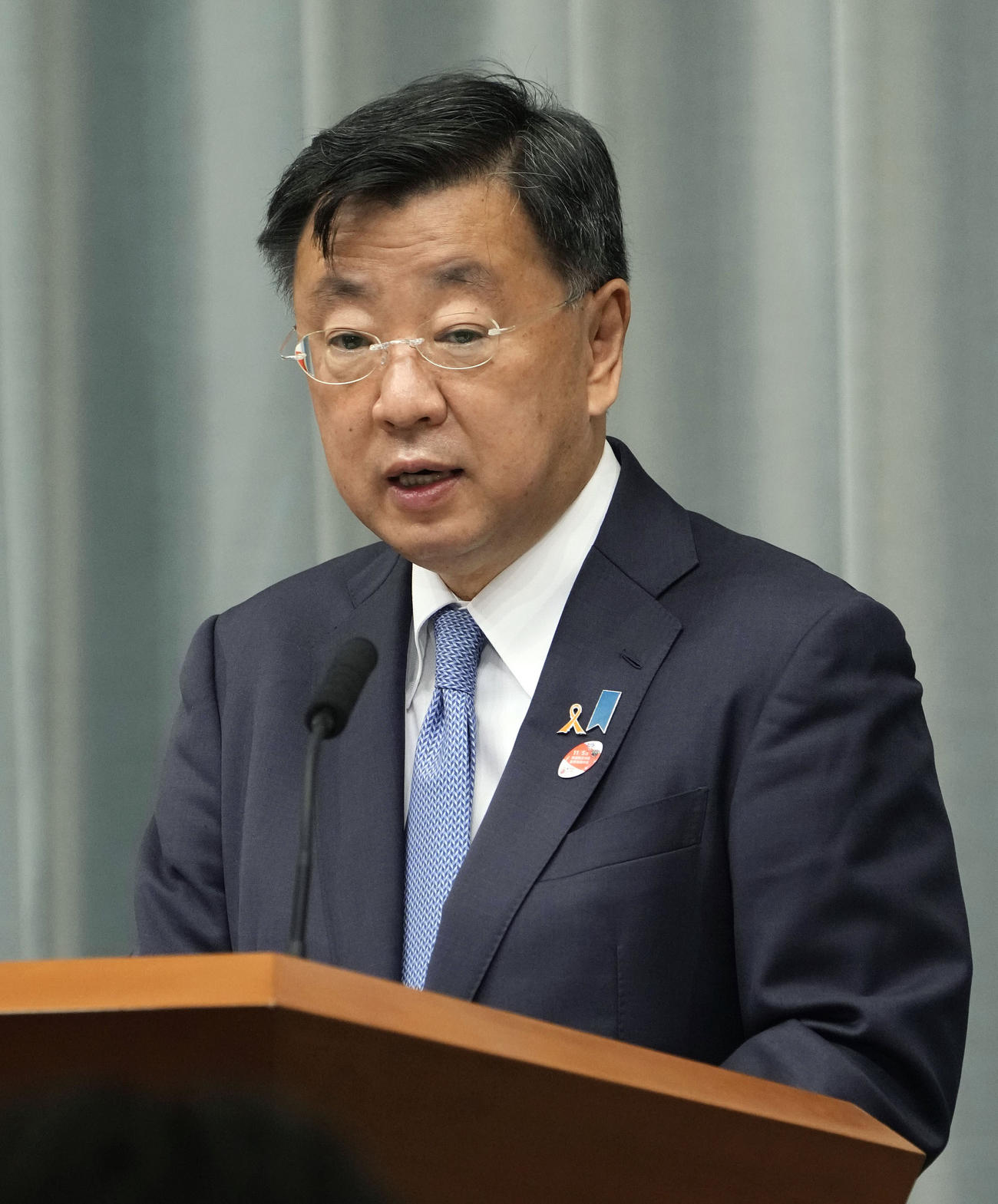 記者会見する松野官房長官（共同）