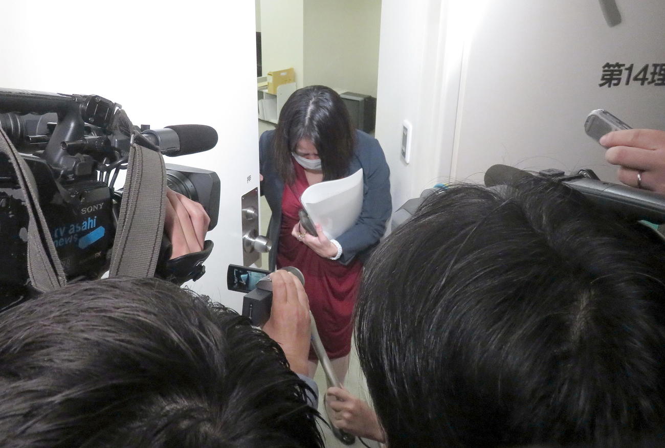 控室に戻る際に報道陣に頭を下げる木下富美子都議（中央）（撮影・鎌田直秀）