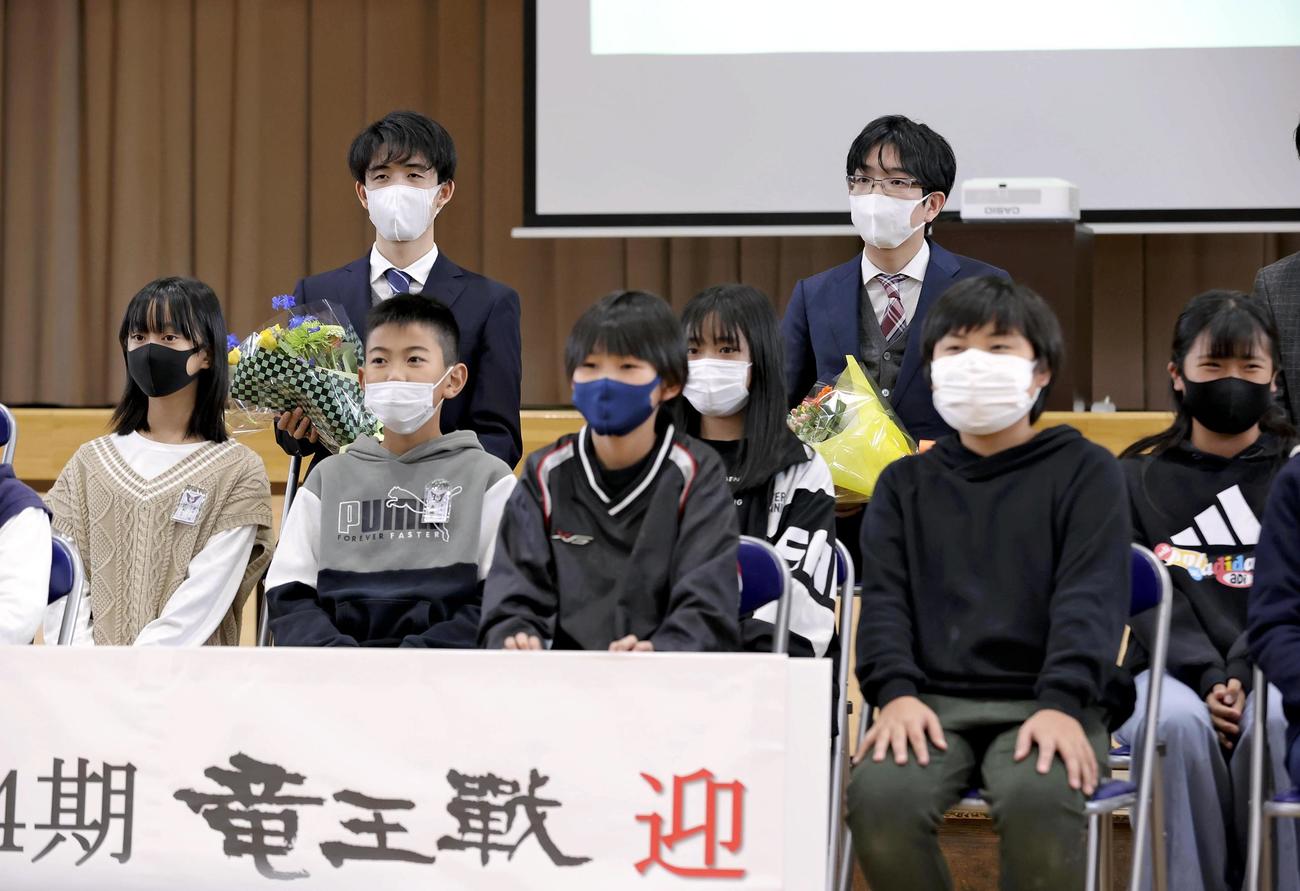 児童との記念撮影に応じる豊島将之竜王（後列右）と藤井聡太三冠（同左）（代表撮影）
