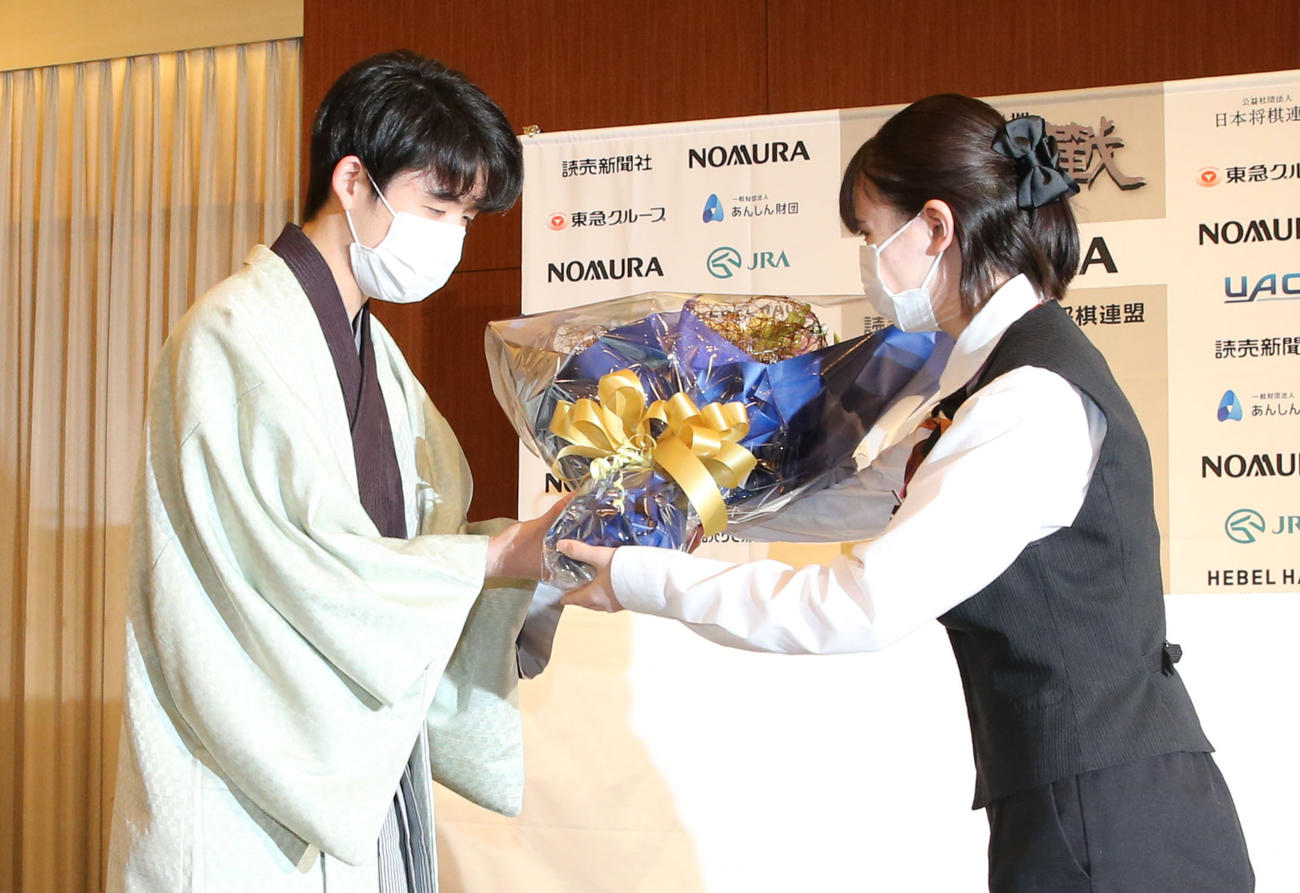 史上初の10代4冠を達成し、花束を受け取る藤井新竜王（撮影・屋方直哉）