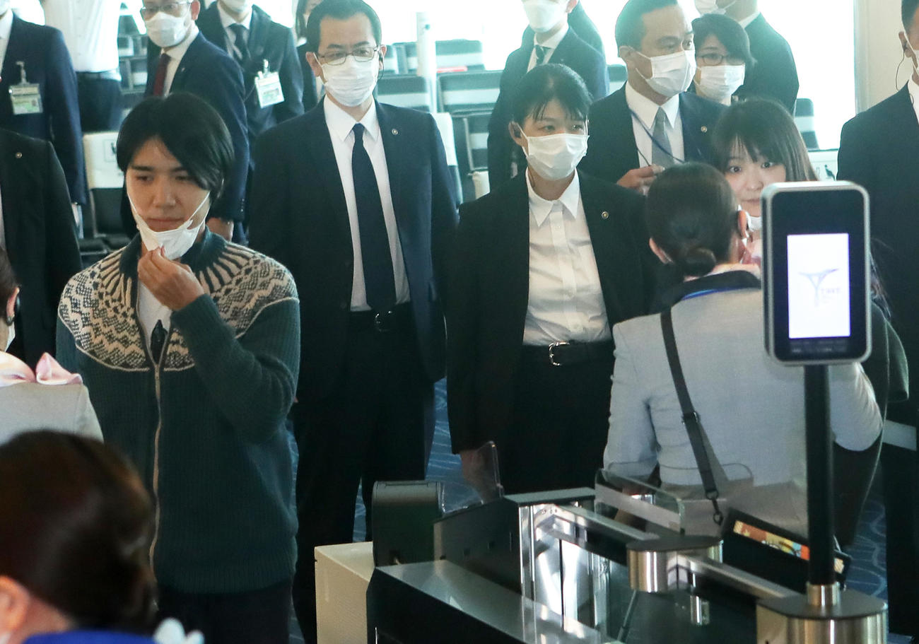 搭乗ゲートでマスクを外す小室圭さん（左）と眞子さん（撮影・足立雅史）