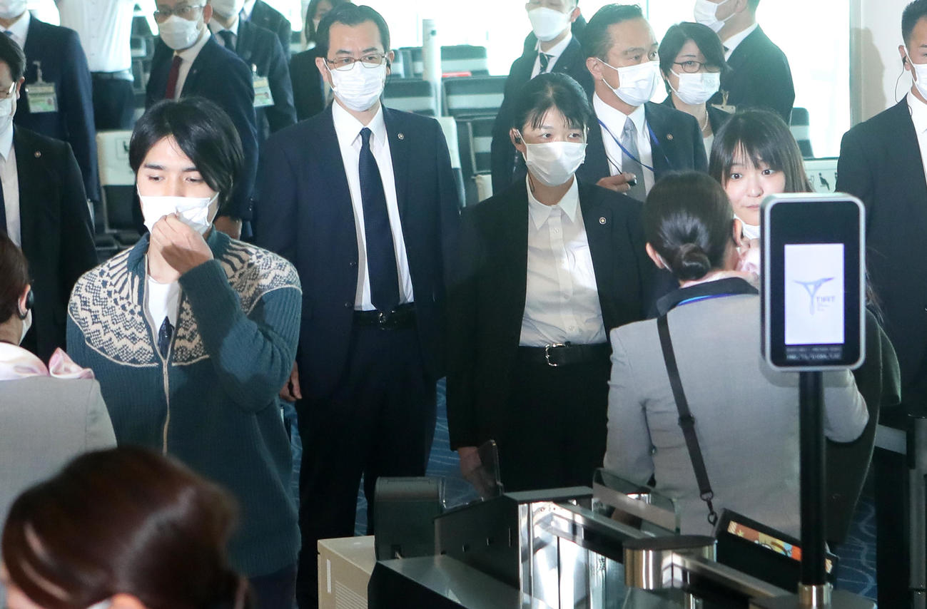 搭乗ゲートでマスクを外す小室圭さん（左）と眞子さん（2021年11月14日撮影）