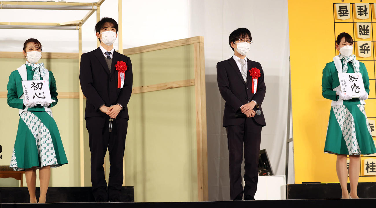 JTプロ公式戦決勝前のあいさつで、子どもたちのプレゼント色紙に「初心」「無倦」と記す、藤井4冠（左から2人目）と豊島JT杯覇者（同3人目）（撮影・狩俣裕三）