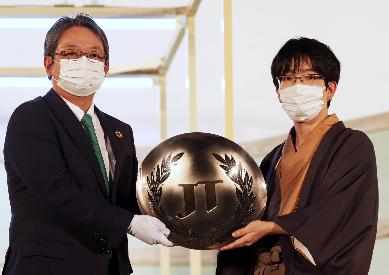藤井聡太竜王を破り、JT杯を手に寺畠JT社長（左）と記念撮影する豊島JT杯覇者（撮影・狩俣裕三）