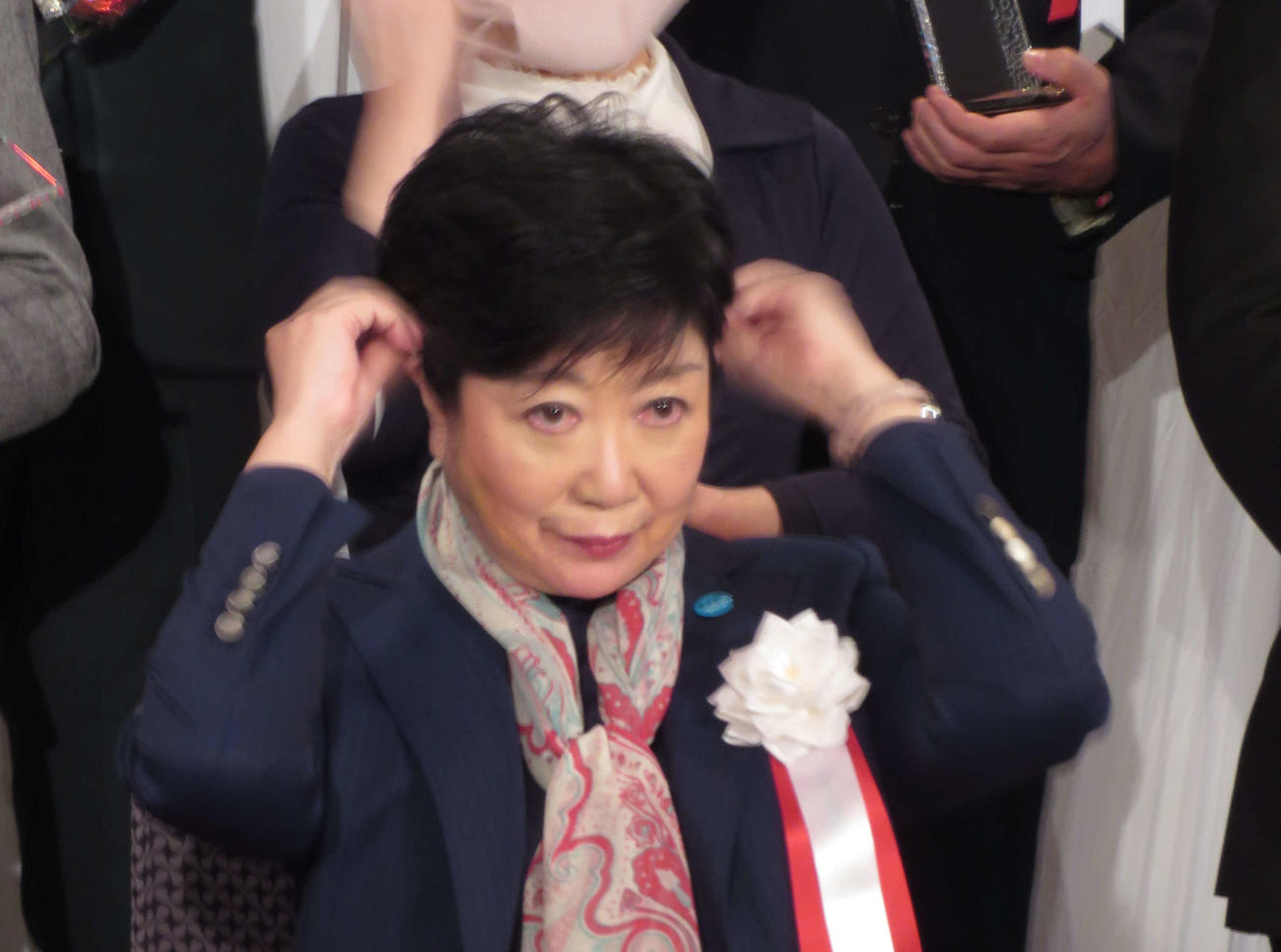 イベント出席者と記念撮影する際にマスクをとり小池百合子都知事ははねた髪の毛を両手で直した（撮影・寺沢卓）