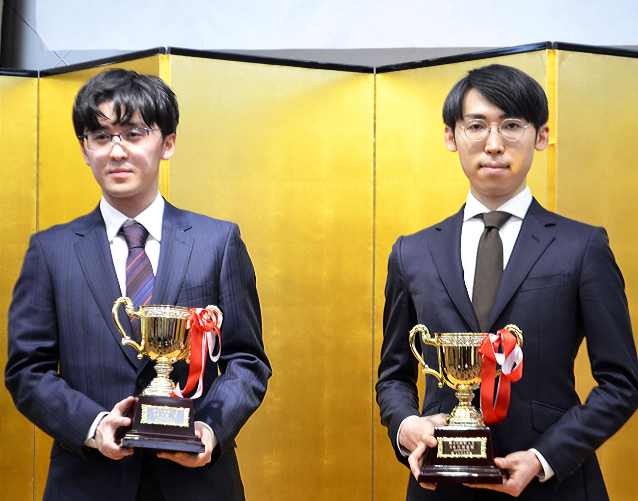 新人王戦の賞杯を手にする将棋の伊藤匠四段（左）と囲碁の外柳是聞三段（撮影・赤塚辰浩）