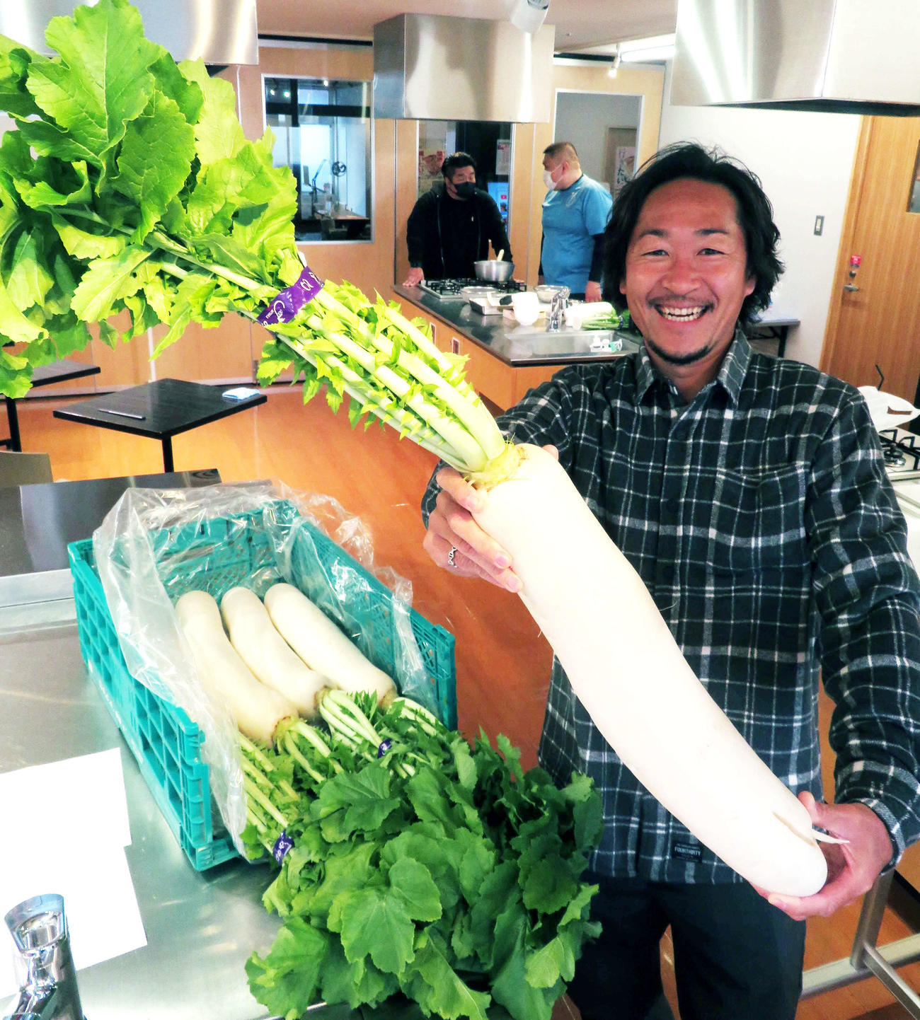 「これ、きれいでしょ」と自作の大根を笑顔で披露する石川さん（撮影・寺沢卓）