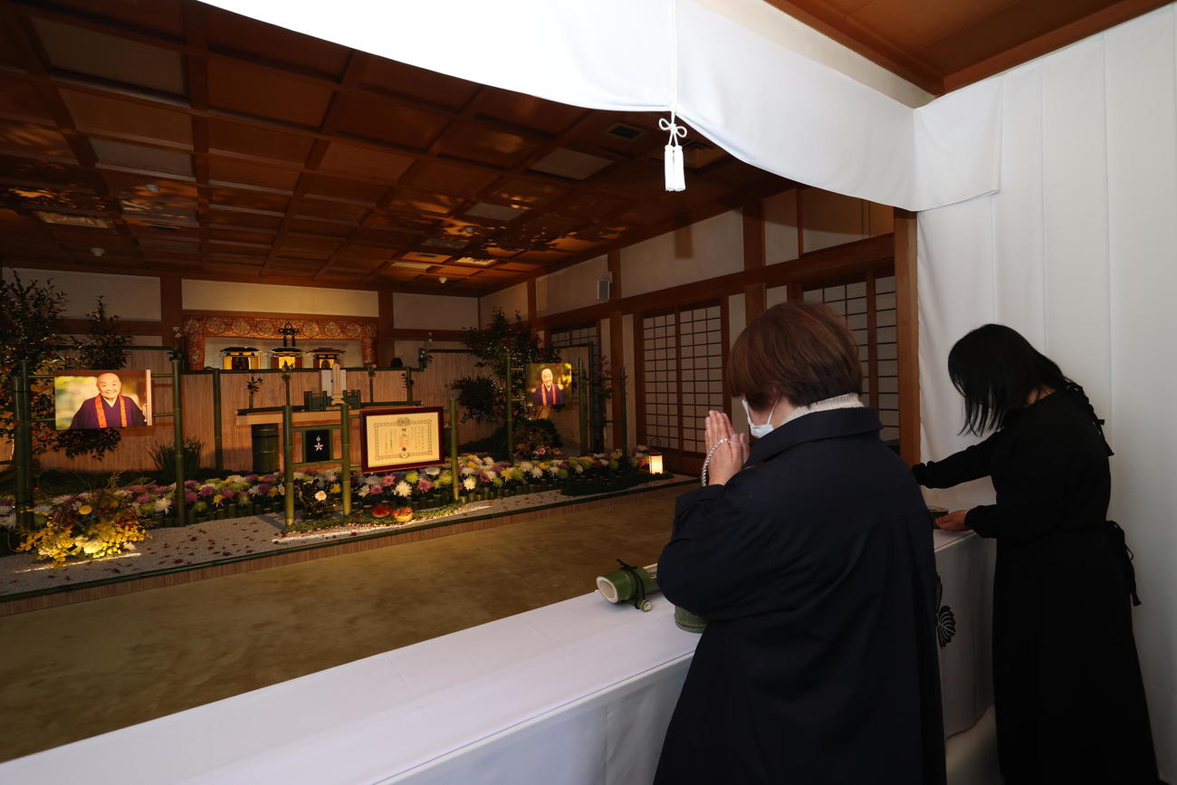 祭壇に手を合わせるファン（代表撮影）