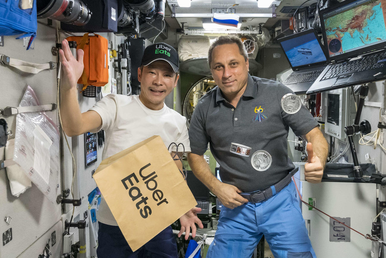 ISSの宇宙飛行士に紙袋を手渡し、ウーバーイーツ史上初の宇宙へのデリバリーを成功させた前澤友作氏（左）（C）SPACETODAY