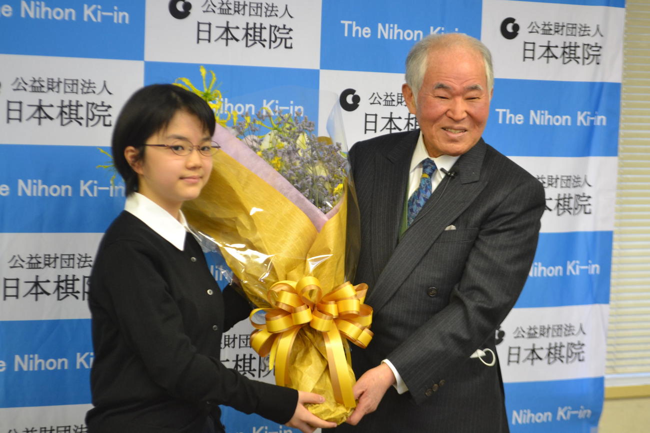 引退会見の終了後、中村菫二段（左）から花束を贈呈された大竹英雄名誉碁聖