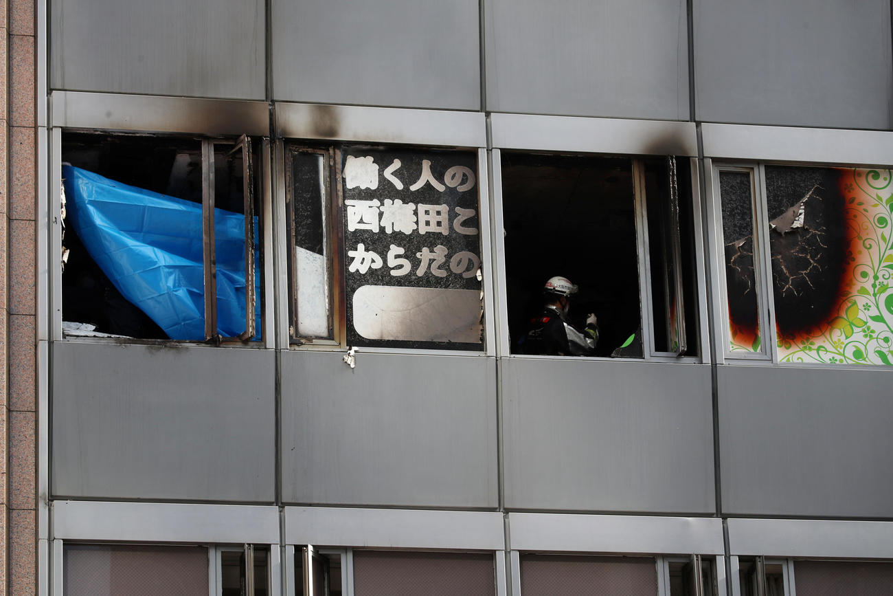 北区曽根崎新地のビル火災で火元の階を点検する消防隊員たちはビニールシートを広げる（撮影・加藤哉）